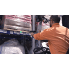 Un opérateur dans un entrepôt est sur un chariot scanne à distance un code-barre avec le terminal industriel skorpio X5, tenu par une poignée