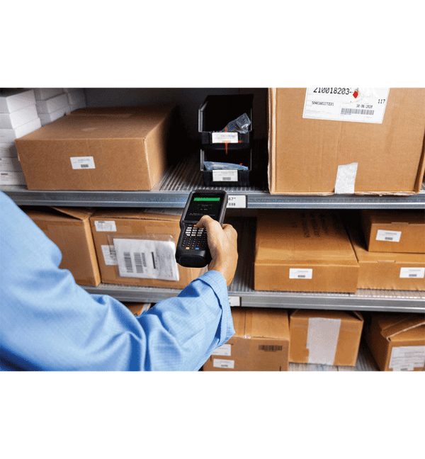 Un opérateur dans un entrepôt prépare une commande et scanne à distance un code-barre avec le terminal industriel skorpio X5 qui a une coque de protection