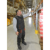 un homme dans un entrepot scanne un code barre sur un carton avec une bague honeywell 8675i scanner mains-libres