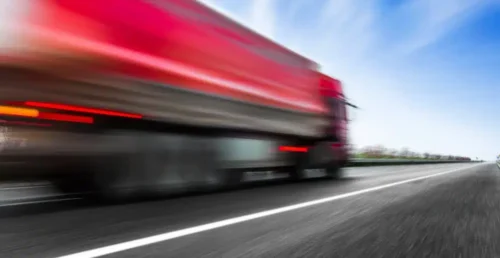 photo_camion_transport_iot_article Camion rouge en mouvement rapide, illustrant la traçabilité des marchandises.