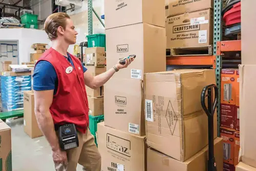 tc72-photography-application-inventory-scaled Employé scannant des boîtes dans un entrepôt avec un PDA.