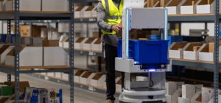 Employé WIIO travaillant avec un robot dans un entrepôt, illustrant les engagements RSE et valeurs WIIO.