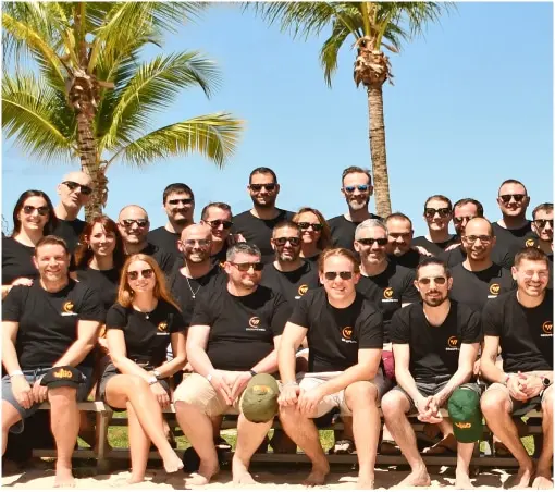 Groupe Wiio : Photo de groupe souriant sous les palmiers.