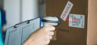 Employé scannant un code-barres sur un colis fragile. Engagements RSE et valeurs WIIO.