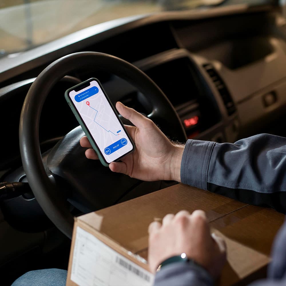 Livreur utilisant une application de supply chain sur son téléphone.
