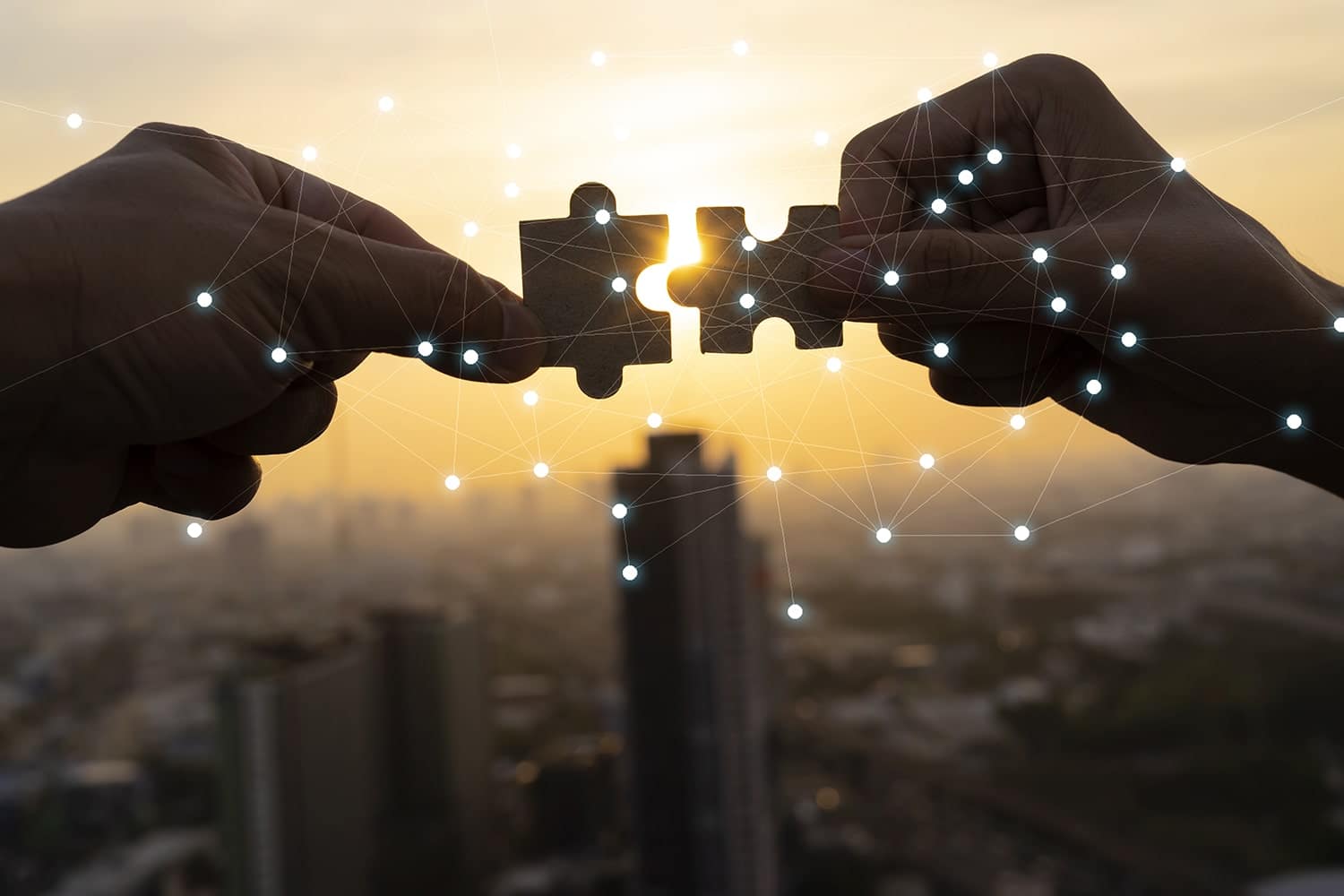 Deux mains assemblant des pièces de puzzle, représentant un éditeur logiciel supply chain.