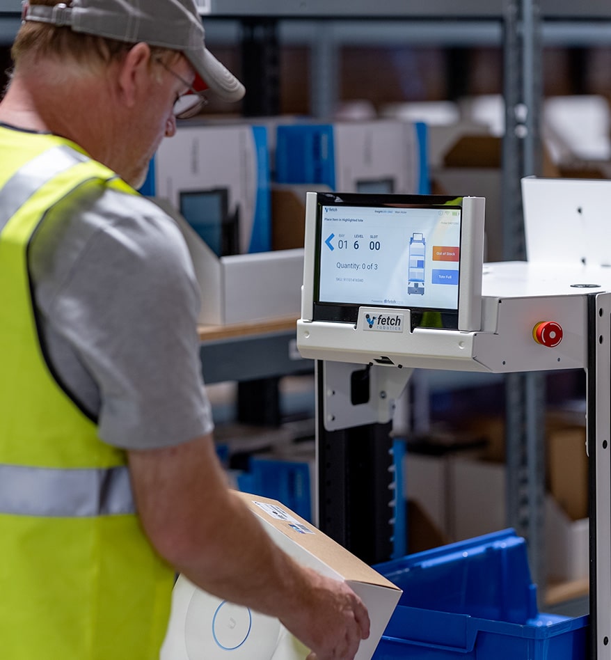 Ouvrier utilisant un robot AMR Zebra Flex dans un entrepôt. L'écran affiche des informations de stock.