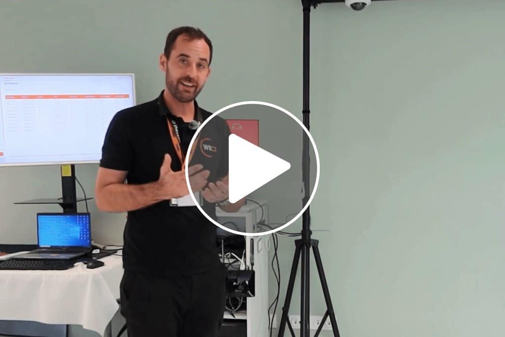 Homme présentant la solution logicielle de tracking vidéo ALTAIIR avec écran et caméra.
