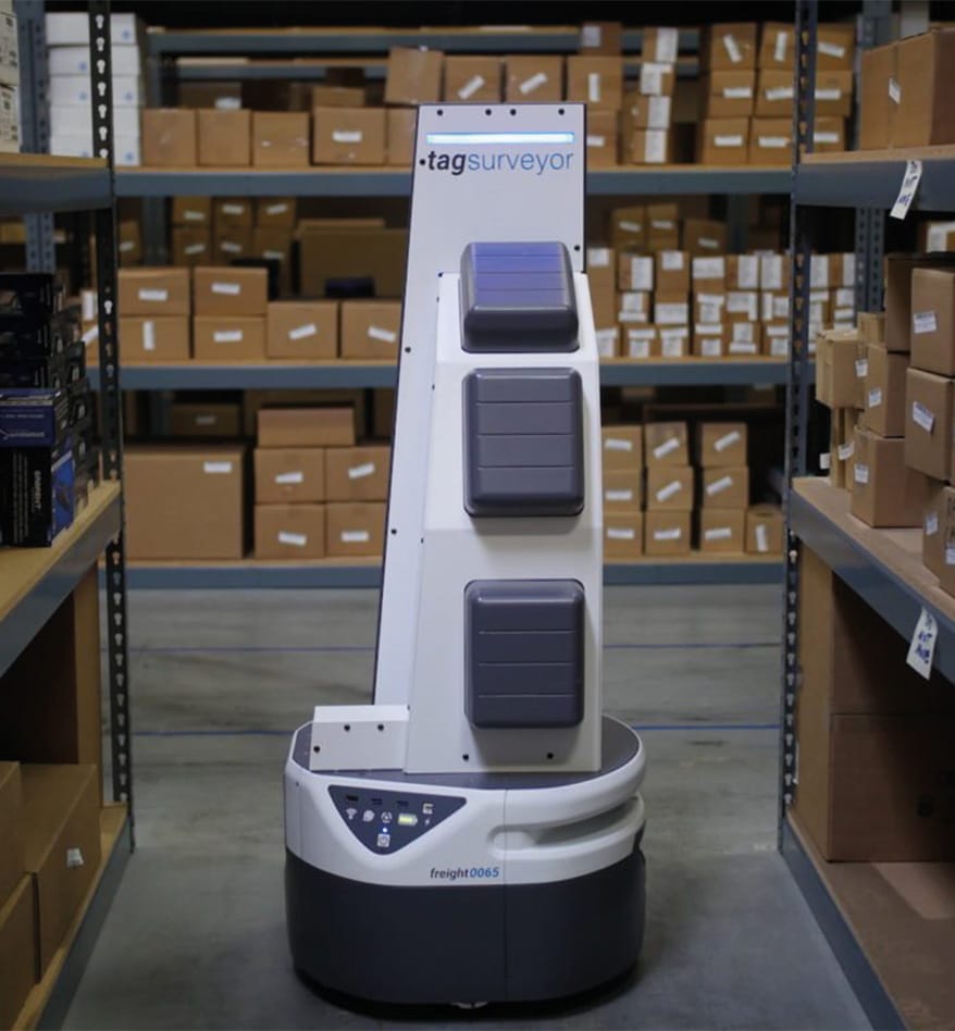 Robot AMR Zebra TagSurveyor RFID dans un entrepôt avec des étagères remplies de boîtes.