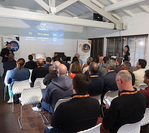 Présentation d'Évènements Groupe V7 avec conférenciers devant un public attentif.