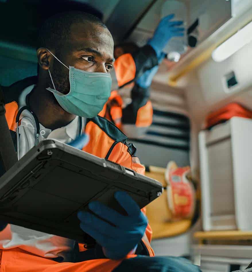 Ambulancier utilisant une tablette durcie Getac ZX10 avec masque et gants.