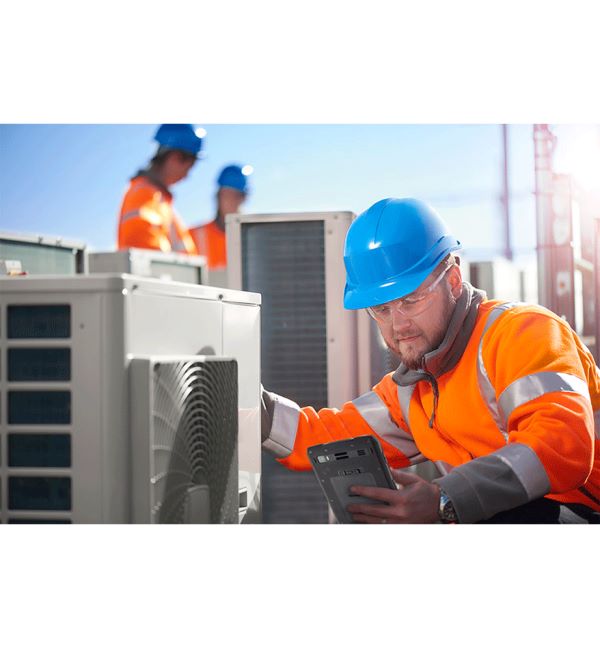 Technicien vérifiant un système HVAC avec un Honeywell EDA71. Équipe de maintenance en arrière-plan.