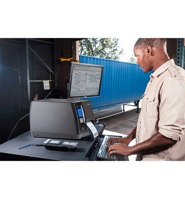 Homme utilisant une imprimante industrielle Honeywell PM45/PM45c dans un entrepôt.