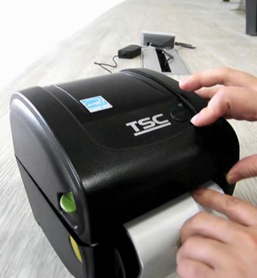 Imprimante de bureau TSC DA210/220 noire avec rouleau de papier.