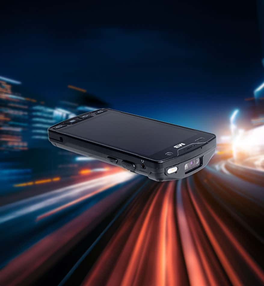 PDA M3 Mobile SM15X sur fond flou de ville nocturne.