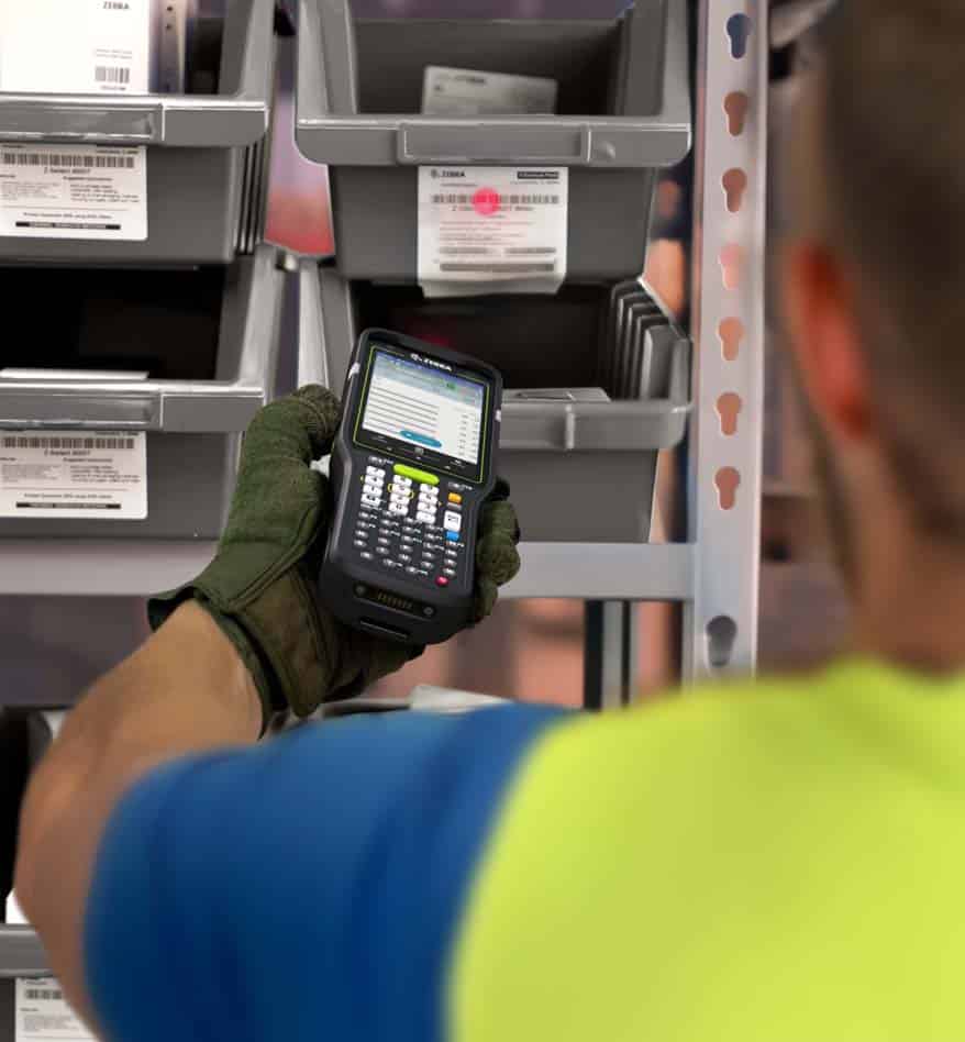 Terminal industriel Zebra MC3400 utilisé dans un entrepôt pour la gestion des stocks.