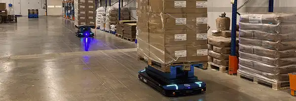 Robots autonomes transportant des palettes dans un entrepôt. Solutions robotiques pour la logistique.