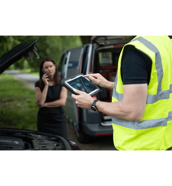 Femme appelant devant une voiture en panne, réparateur utilisant une tablette durcie Panasonic Toughbook G2.