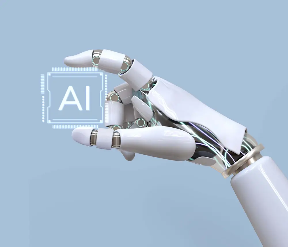 Main robotique tenant une puce "AI". Glossaire A-J.