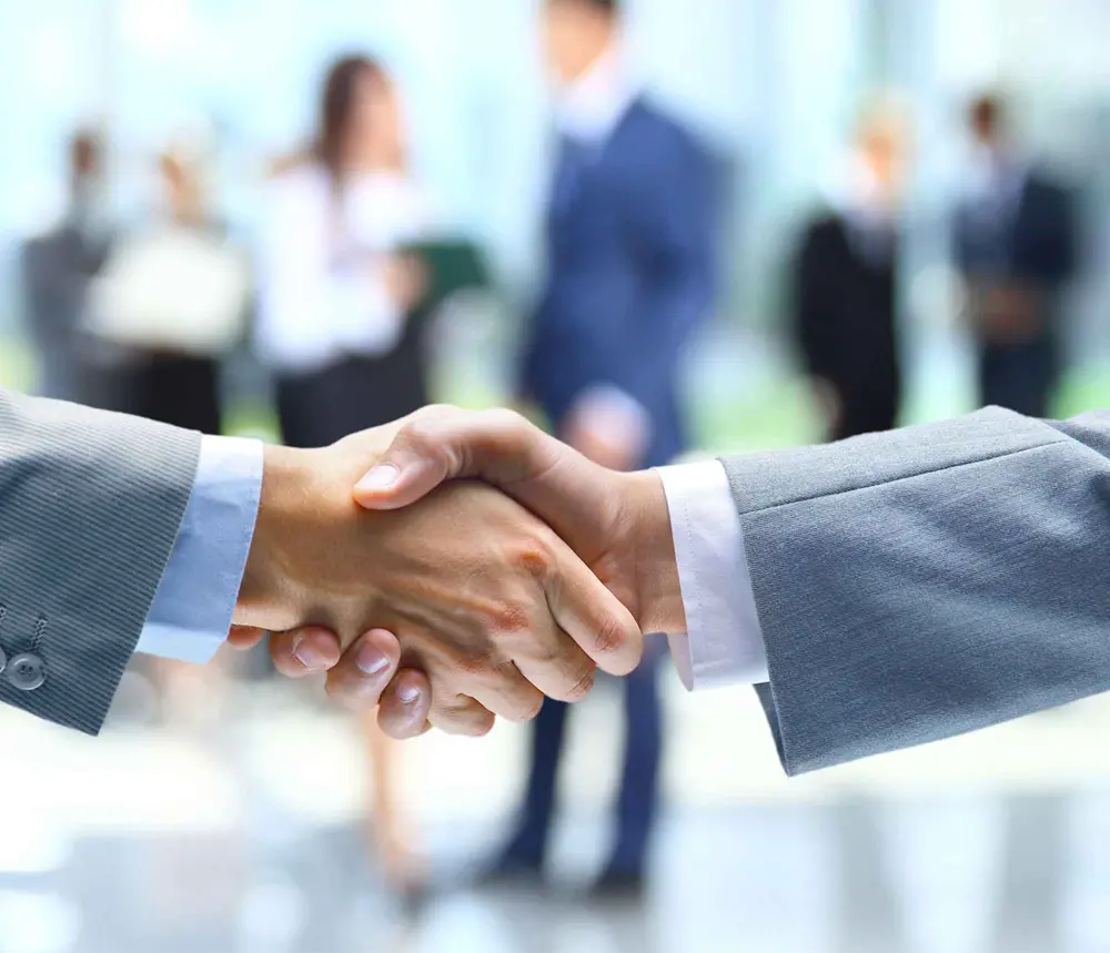 Poignée de main entre deux professionnels. Glossaire A-J.