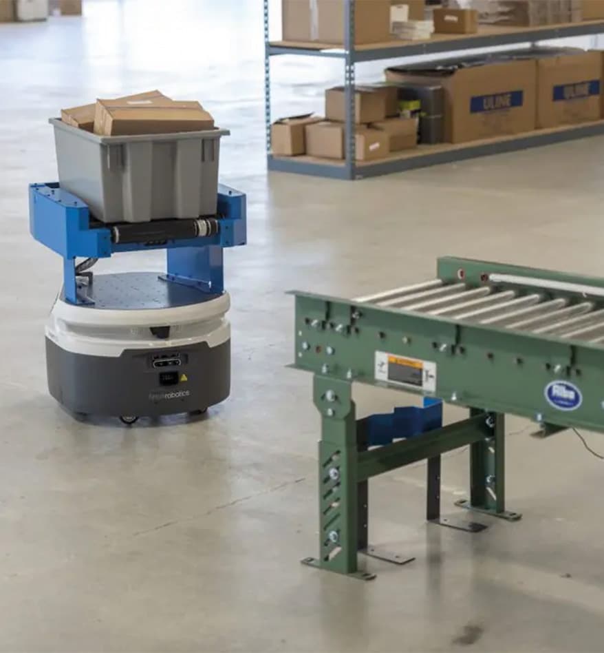 Robot AMR Zebra Roller Series transportant un bac dans un entrepôt.