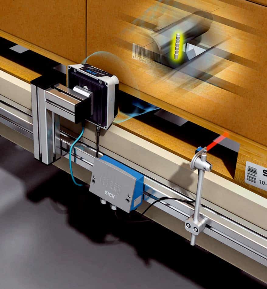 Lecteur RFID SICK RFU65x détectant un code-barres sur un carton en mouvement.