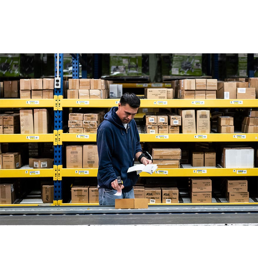 Employé utilisant un scanner RS5100 Zebra dans un entrepôt pour scanner des boîtes.