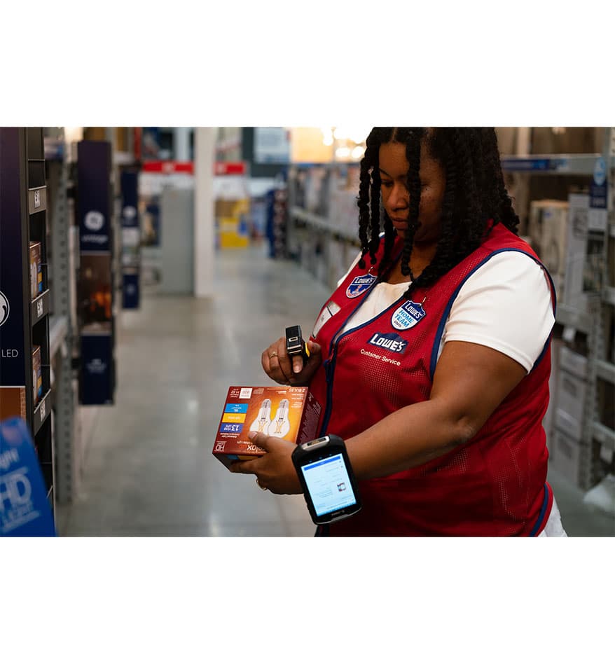 Employée de Lowe's utilisant le scanner RS5100 Zebra pour vérifier un produit.