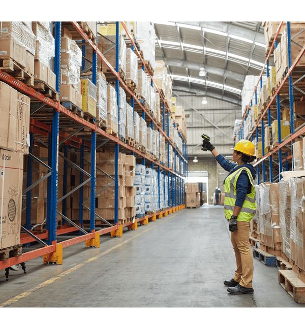 Employée d'entrepôt scannant avec le Scanner DS3600-KD Zebra dans un entrepôt rempli d'étagères.