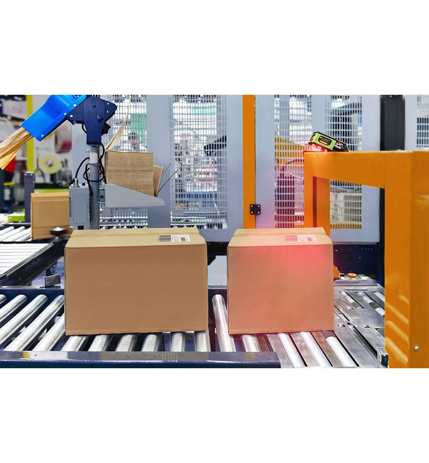 Boîtes sur convoyeur avec scanner FS40 Zebra pour automatisation d'entrepôt.