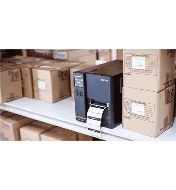 Imprimante industrielle Brother TJ-4121TN imprimant une étiquette dans un entrepôt avec des cartons.