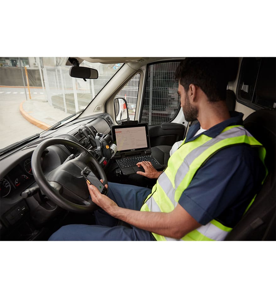 Homme utilisant une tablette durcie Zebra ET80/ET85 dans un véhicule.