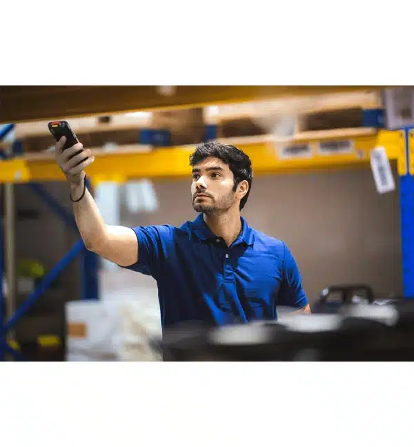 Homme utilisant un terminal mobile EDA52 Honeywell dans un entrepôt.