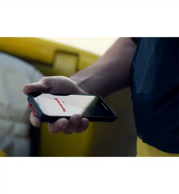 Un homme tient un terminal mobile EDA52 Honeywell. L'écran affiche le logo Honeywell.