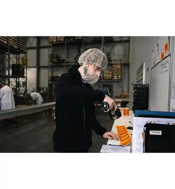 Employé scannant des produits dans un entrepôt avec un terminal industriel Honeywell CK65.