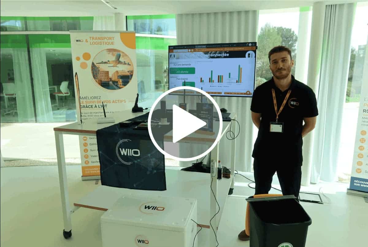 Solution logicielle IoT WIITRACK présentée sur un stand avec écran d'analyse de données. Transport et logistique.