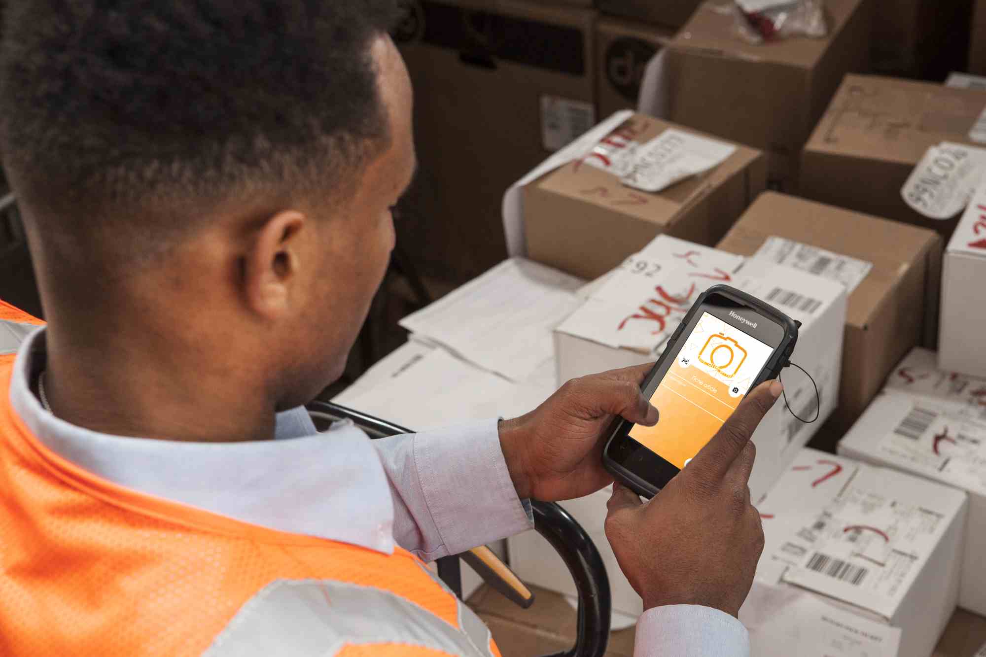 Employé utilisant une solution logicielle de tracking vidéo ALTAIIR pour scanner des colis.