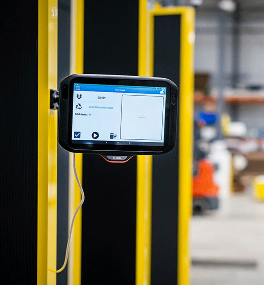 Panel PC Zebra CC6000 fixé sur une structure jaune et noire dans un entrepôt.