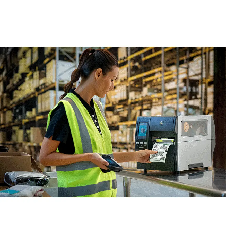 Employée utilisant une imprimante industrielle Zebra ZT411 dans un entrepôt.