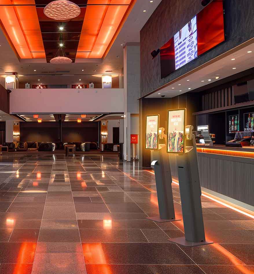 Ordinateur type kiosque Zebra KC50 dans un hall d'hôtel moderne avec éclairage orange.