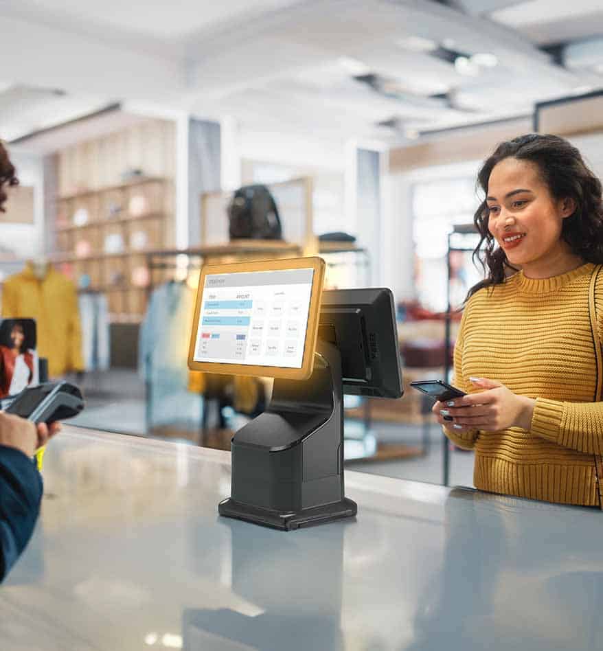 Ordinateur type kiosque Zebra KC50 dans un magasin de vêtements, avec une cliente souriante.