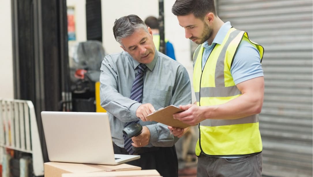 Deux employés WIIO vérifient l'inventaire avec un ordinateur portable et un lecteur de codes-barres.