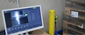 Écran de contrôle qualité affichant des données de pilotage et remontée des kpi, palettes en arrière-plan.