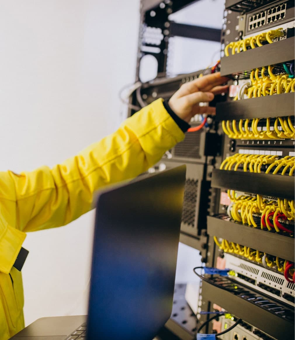 Technicien vérifiant l'infrastructure réseau avec un ordinateur portable. Pilotage et remontée des KPI.