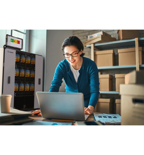 Femme utilisant une tablette Zebra ET40-45 près d'une station de chargement.