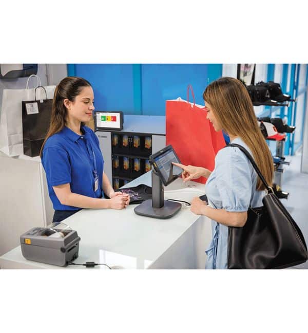 Client utilisant une tablette Zebra ET40-45 à la caisse avec une employée.