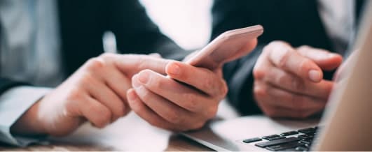 Personnes utilisant une solution logicielle de tracking vidéo ALTAIIR sur un téléphone et un ordinateur portable.