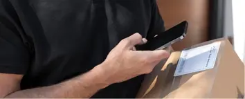 Livreur scannant un colis. Pilotage et remontée des KPI pour le contrôle qualité.