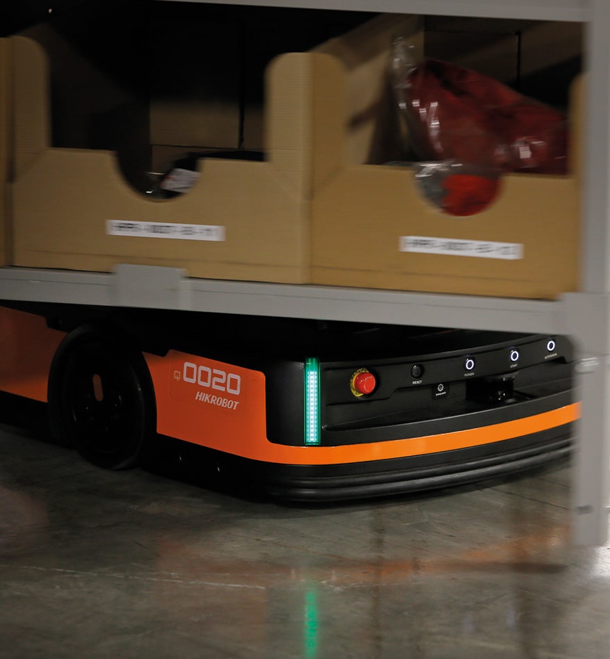 Robot LMR HIKRobot transportant des boîtes dans un entrepôt. On voit le numéro 0020 sur le robot.