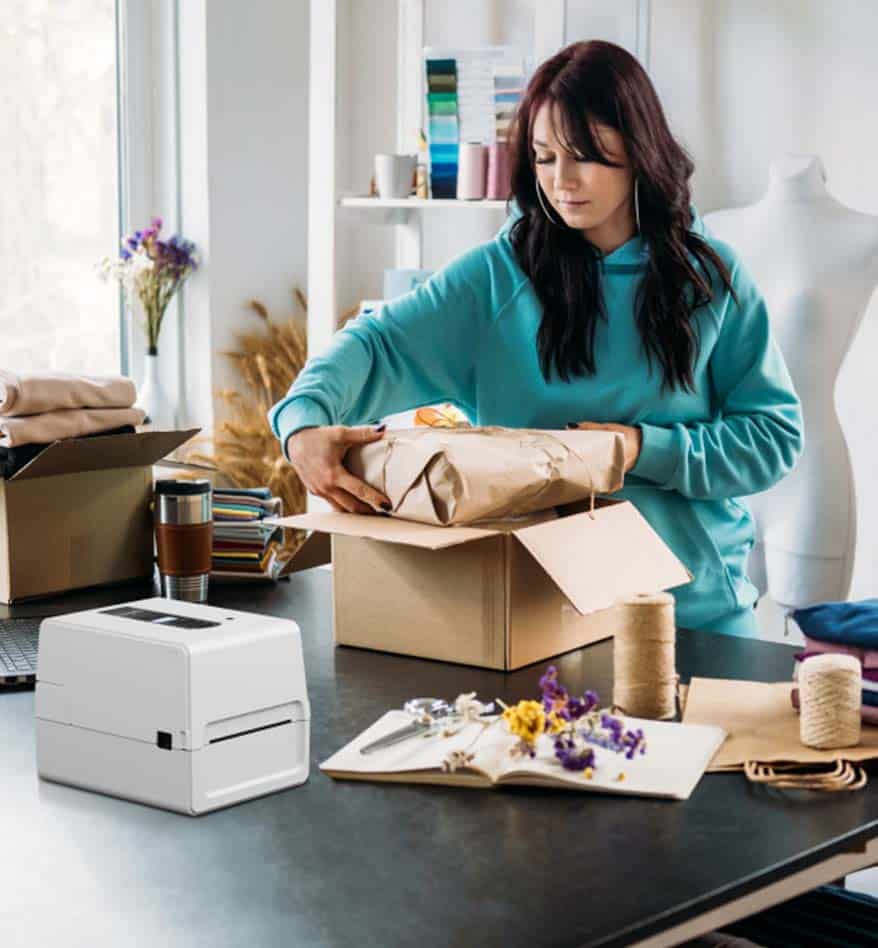 Femme emballant un colis près de l'imprimante de bureau Toshiba BV410T.